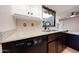 Updated kitchen features stone countertops, black appliances, and dark wood cabinets at 4916 E Hopi St, Phoenix, AZ 85044