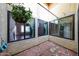 Enclosed patio with brick-laid flooring, views into the home, and a hanging planter, great for relaxing at 4916 E Hopi St, Phoenix, AZ 85044