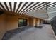 Covered patio area featuring neutral-colored stucco walls, concrete flooring, and sliding glass doors at 4916 E Hopi St, Phoenix, AZ 85044