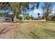 Expansive backyard featuring a lush lawn, mature trees, and a charming home in the background at 5112 N 41St St, Phoenix, AZ 85018