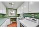 Well-lit laundry room featuring wallpaper, brick floors, storage cabinets, and modern appliances at 5112 N 41St St, Phoenix, AZ 85018