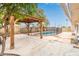 Backyard with an inground pool surrounded by a mesh fence and wooden pergola at 5525 N 21St Ave, Phoenix, AZ 85015