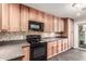 Kitchen with wood cabinets, black appliances and decorative backsplash at 5525 N 21St Ave, Phoenix, AZ 85015