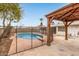 Backyard inground pool surrounded by a mesh fence and covered lounge area at 5525 N 21St Ave, Phoenix, AZ 85015