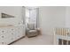 Serene Bedroom featuring a dresser with a changing pad, a comfortable glider, and a crib at 5650 S Feliz --, Mesa, AZ 85212