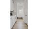 Bright hallway with white cabinetry, beadboard accent wall, light wood flooring, and a cozy bench at 5650 S Feliz --, Mesa, AZ 85212