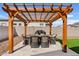 Outdoor kitchen featuring a grill and dining seating under a custom-built pergola with stone flooring at 5650 S Feliz --, Mesa, AZ 85212