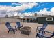 An outdoor fire pit with seating in a backyard with rock groundcover and a covered patio at 6119 N 18Th Dr, Phoenix, AZ 85015