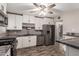 This kitchen features stainless steel appliances, white cabinets with black hardware, and wood-look tile floors at 6119 N 18Th Dr, Phoenix, AZ 85015
