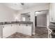 An open kitchen view showcasing white cabinetry, gray countertops, wood-look tile flooring, and a breakfast bar at 6119 N 18Th Dr, Phoenix, AZ 85015