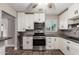 A well-lit kitchen features stainless steel appliances, white cabinetry, gray subway tile backsplash, and wood-look tile flooring at 6119 N 18Th Dr, Phoenix, AZ 85015