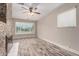 A simple living room featuring wood-look tile flooring, a cozy fireplace, and ample natural light at 6119 N 18Th Dr, Phoenix, AZ 85015