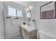 Bathroom featuring a modern vanity, oval mirror, and natural light at 6943 E Granada Rd, Scottsdale, AZ 85257
