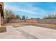 Large, enclosed backyard with block fencing and a partially covered concrete patio at 7017 W Beatrice St, Phoenix, AZ 85043