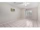 Well-lit bedroom with neutral walls, tiled flooring, a window and a ceiling fan at 7017 W Beatrice St, Phoenix, AZ 85043