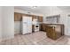Well-lit kitchen with wood cabinets, white appliances, and tile flooring for a clean look at 7017 W Beatrice St, Phoenix, AZ 85043