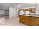 Open kitchen featuring wood cabinets, white appliances, and adjacent to the living area at 7017 W Beatrice St, Phoenix, AZ 85043
