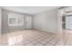 Inviting living room featuring durable tile flooring, a spacious layout, and ample natural light from a large window at 7017 W Beatrice St, Phoenix, AZ 85043