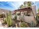 Inviting front patio area with a wooden pergola and a variety of desert plants in a serene setting at 7920 E Via Camello -- # 48, Scottsdale, AZ 85258