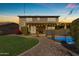 Beautiful backyard featuring a pool, lush lawn, and cozy patio with charming string lights, perfect for outdoor relaxation at 8761 W Mary Ann Dr, Peoria, AZ 85382