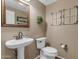 Elegant powder room with a pedestal sink, decorative mirror, and wall art at 8761 W Mary Ann Dr, Peoria, AZ 85382