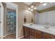 Bright bathroom featuring a double sink vanity with dark wood cabinets and a shower with a patterned curtain at 8761 W Mary Ann Dr, Peoria, AZ 85382