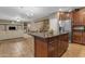 Open-concept kitchen island with granite countertops next to a stainless steel refrigerator at 8761 W Mary Ann Dr, Peoria, AZ 85382