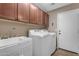 Functional laundry room with sink, washer, dryer, and upper cabinets offering ample storage space at 8761 W Mary Ann Dr, Peoria, AZ 85382