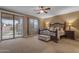 Relaxing bedroom with a decorative bed frame, ceiling fan, and sliding door to the backyard at 8761 W Mary Ann Dr, Peoria, AZ 85382