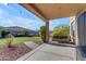 Relaxing covered patio with a porch swing, overlooking a well-manicured lawn and beautifully landscaped backyard at 8761 W Mary Ann Dr, Peoria, AZ 85382