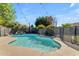 Sparkling pool with waterfall feature, surrounded by lush landscaping and a secure safety fence at 8761 W Mary Ann Dr, Peoria, AZ 85382