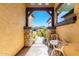 Cozy front patio framed with stone columns, offering a tranquil sitting area and a view of the neighborhood at 9754 E Barley Rd, Florence, AZ 85132