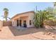 Back exterior view of a home with covered patio and desert landscaping, including cactus and palm trees at 9922 E Onza Ave, Mesa, AZ 85212