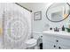 Stylish bathroom with modern fixtures, decorative shower curtain, round mirror, and a clean, well-lit vanity at 9922 E Onza Ave, Mesa, AZ 85212