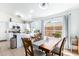 Charming dining area adjacent to the kitchen, featuring a wooden table, chairs, and a bright window at 9922 E Onza Ave, Mesa, AZ 85212