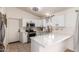 Stylish kitchen showcasing white cabinetry, modern appliances, and a convenient breakfast bar at 9922 E Onza Ave, Mesa, AZ 85212