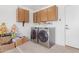 Functional laundry room with ample cabinet storage and modern washer and dryer units for convenience at 9922 E Onza Ave, Mesa, AZ 85212