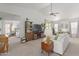 Comfortable living room with a ceiling fan, TV, shelving, and an adjacent room with a bed at 9922 E Onza Ave, Mesa, AZ 85212
