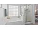 Bright main bathroom with a glass block window above a tub and a separate glass-enclosed shower at 9922 E Onza Ave, Mesa, AZ 85212