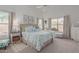 Light and airy primary bedroom with two large windows, carpet floors, and leafy patterned linens at 9922 E Onza Ave, Mesa, AZ 85212