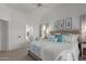 Bright main bedroom featuring a ceiling fan, neutral walls, carpet floors, and ensuite bathroom access at 9922 E Onza Ave, Mesa, AZ 85212