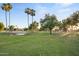 Lush green spaces and serene ponds create a tranquil community setting with abundant trees and open lawns at 10909 W Santa Fe Dr, Sun City, AZ 85351