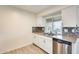 Bright kitchen with a stainless steel sink, white cabinets, and sleek countertops at 10909 W Santa Fe Dr, Sun City, AZ 85351