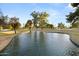 A serene community pond offers a peaceful retreat with lush surroundings and clear waters for resident enjoyment at 10909 W Santa Fe Dr, Sun City, AZ 85351