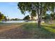 Scenic view of a tranquil pond surrounded by lush greenery and mature trees at 10909 W Santa Fe Dr, Sun City, AZ 85351