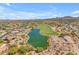 Beautiful aerial view featuring a golf course, serene pond, and surrounding community homes with mountain backdrop at 10931 S Santa Columbia Dr, Goodyear, AZ 85338
