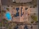 Aerial view of desert home with solar panels, inviting pool and lounge area, and desert landscaping at 10931 S Santa Columbia Dr, Goodyear, AZ 85338