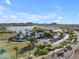 Community aerial view features a resort-style pool, lush landscaping, lake and mountain views at 10931 S Santa Columbia Dr, Goodyear, AZ 85338
