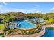 Aerial view of a large resort-style community pool with blue lounge chairs and a splash pad at 10931 S Santa Columbia Dr, Goodyear, AZ 85338