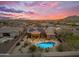 Aerial view of a desert home featuring a pool, patio, fenced yard, desert landscaping, and solar panels at 10931 S Santa Columbia Dr, Goodyear, AZ 85338